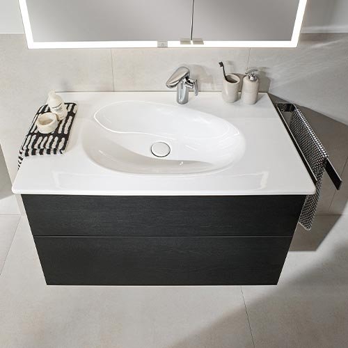 Ein elegantes Waschbecken mit einem modernen, weißen Becken und einem stilvollen schwarzen Unterschrank.