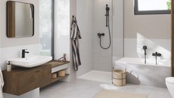 Ein modernes Badezimmer mit einer eleganten Badewanne, einer Dusche und einem stilvollen Waschbecken aus weißem Keramik.